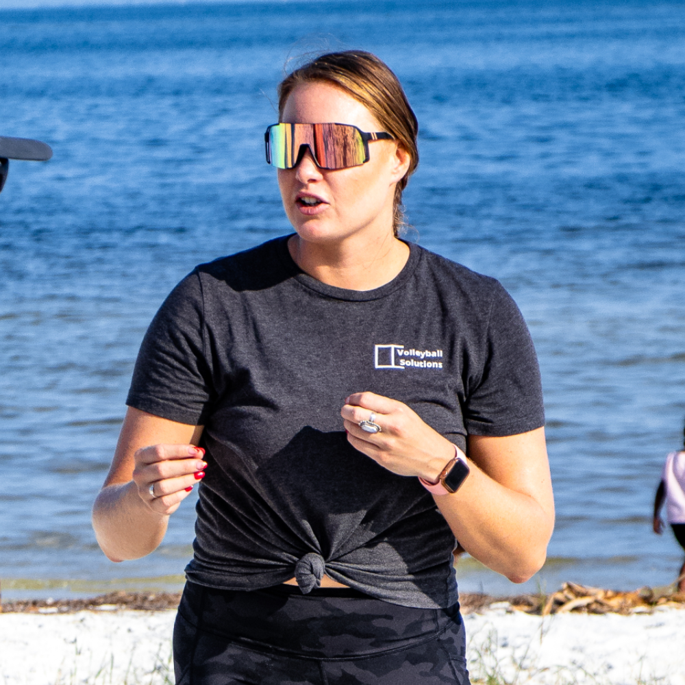 Coach Alyx of Volleyball Solutions working with a student during a beach volleyball class